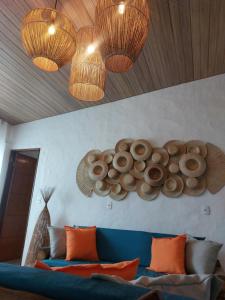 a living room with a blue couch and two lights at Pousada Rocas Beach in Pôrto de Pedras