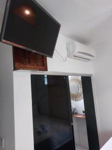 a room with a tv on the wall and a window at Pousada Rocas Beach in Pôrto de Pedras
