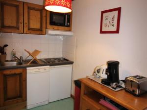 uma cozinha com um lavatório e um fogão forno superior em Appartement Lanslebourg-Mont-Cenis, 3 pièces, 6 personnes - FR-1-508-255 em Lanslebourg-Mont-Cenis