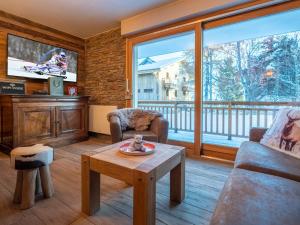 a living room with a table and a large window at Appartement rénové au cœur de l'Alpe d'Huez avec Wifi et Parking - FR-1-645-24 in LʼHuez