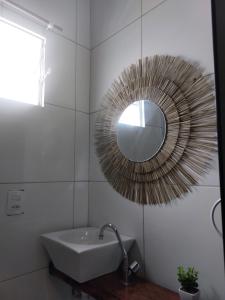 a bathroom with a sink and a mirror on the wall at Pousada Rocas Beach in Pôrto de Pedras