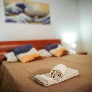 une serviette pliée assise au-dessus d'un lit dans l'établissement Blue Wave Holiday House, à Aci Castello