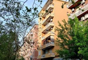 - un grand bâtiment jaune avec un balcon dans l'établissement Casa Publicola, à Rome