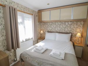 a bedroom with a bed with two towels on it at Foxglove in Leominster