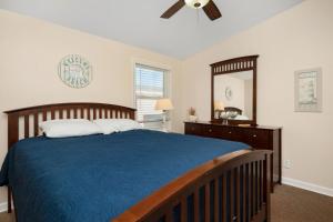a bedroom with a bed and a ceiling fan at This Is It by Oak Island Accommodations in Oak Island