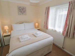 een slaapkamer met een bed met twee handdoeken erop bij Daffodil in Leominster