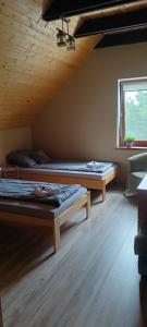 利茲巴克的住宿－Rajski Azyl，客房设有两张床和窗户。