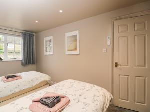 a bedroom with two beds and a door at Well Cottage in Malmesbury +5 photos