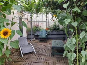 a patio with two chairs and a table and a sunflower at KACHOUR MAZA in Montfermeil