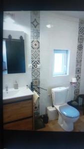 ein Bad mit einem WC, einem Waschbecken und einem Fenster in der Unterkunft KACHOUR MAZA in Montfermeil