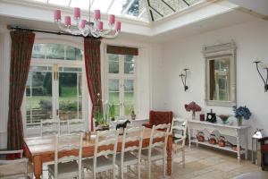 uma sala de jantar com uma mesa e um lustre em Helmdon House Bed and Breakfast em Helmdon