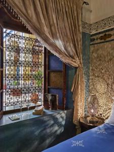 um quarto com uma cama e uma janela com cortinas em Palais didi em Meknès