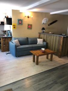 a living room with a blue couch and a coffee table at Les Cazes Hermitage 4-Proche Lagon in L'Ermitage-Les-Bains