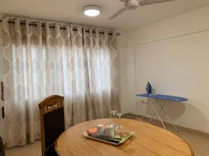 une chambre avec une table en bois et un rideau dans l'établissement One Bedroom Cozy Apartment- KNUST & free Parking, à Kumasi