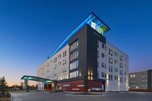 a hotel with a lit up sign on top of it at Aloft Waco Downtown in Waco
