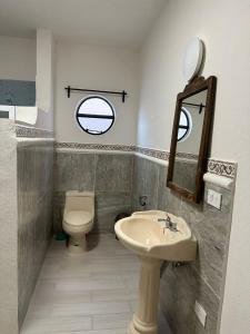 La salle de bains est pourvue d'un lavabo, de toilettes et d'un miroir. dans l'établissement Bebelines inn dos, à San Miguel de Allende