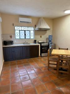 a large kitchen with a table and a stove at Bebelines inn dos in San Miguel de Allende