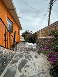 um banco branco sentado fora de um edifício em Bebelines inn dos em San Miguel de Allende