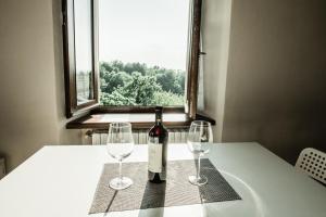 una botella de vino sentada en una mesa con dos copas en La Casa di Roby-2 studio la morra en La Morra