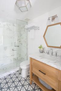 a bathroom with a toilet and a sink and a mirror at Lido House, Autograph Collection in Newport Beach