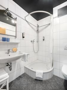 Baño blanco con bañera y lavamanos en Vier Jahreszeiten en Würzburg