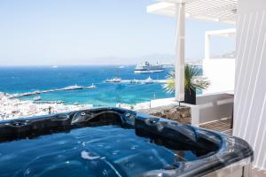 a bath tub with a view of the ocean at Νumi Boutique Hotel in Mikonos