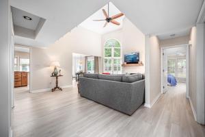 uma sala de estar com um sofá e uma ventoinha de tecto em The Cozy Cottage - 10 Min From UNC em Chapel Hill