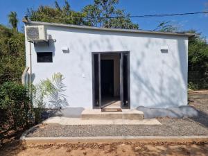 a small white building with a door and stairs at Einfamilienhaus (neu) in Paraguay, Areguá. 25 km nach Asuncion. in Areguá
