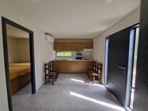 a room with a bed and a kitchen with chairs at Einfamilienhaus (neu) in Paraguay, Areguá. 25 km nach Asuncion. in Areguá