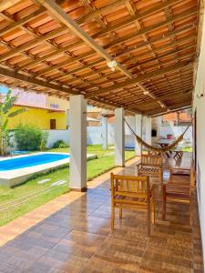 a patio with two wooden chairs and a hammock at Casa Egípcia em Morro branco - na quadra da praia in Morro Branco