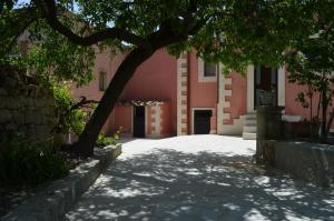 uma árvore em frente a um edifício rosa em Antico Casale Pizzo em Palazzolo Acreide
