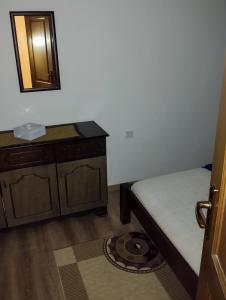 mały pokój z łóżkiem i lustrem w obiekcie Meadow's Edge - Charming Rustic Escape w mieście Cetynia