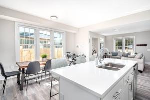 a white kitchen and living room with a couch at Cozy Ranch New Build 3 bed 2 bath in Durham