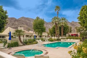 een zwembad met palmbomen en bergen op de achtergrond bij Casa La Quinta Permit# 66,014 in La Quinta