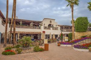 een gebouw met palmbomen en bloemen op een straat bij Casa La Quinta Permit# 66,014 in La Quinta