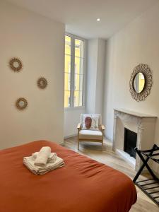 1 dormitorio con cama, silla y espejo en Charmant 3 pièces à Nice en Niza