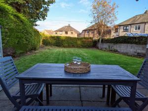 a picnic table with a basket and two glasses on it at Parkview Cottage - Lovely home overlooking park in Carnoustie