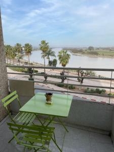 uma mesa e cadeiras numa varanda com vista para um rio em كوثر em Kenitra