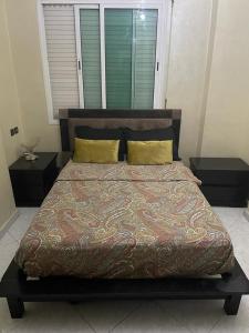 um quarto com uma cama grande e 2 mesas de cabeceira em كوثر em Kenitra