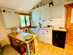 a kitchen with white cabinets and a wooden table at Cesemino Farmhouse in Czyżemin +15 photos