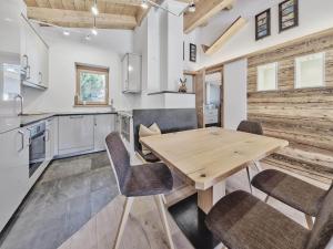 a kitchen with a wooden table and chairs at Ferienhaus 12 im Feriendorf Kirchdorf in Kirchdorf in Tirol +3 photos