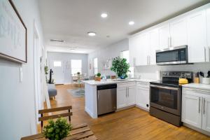 a kitchen with white cabinets and black appliances at Cozy Stylish Chic Home Ybor, Dt Central Location in Tampa