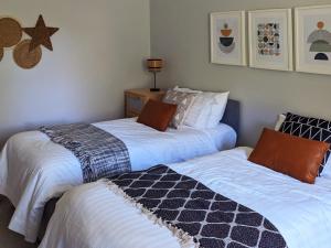 duas camas sentadas uma ao lado da outra num quarto em Parkview Cottage - Lovely home overlooking park em Carnoustie