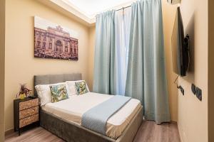 um pequeno quarto com uma cama e uma televisão em Musa Rooms Roma em Roma