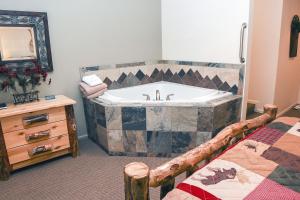łazienka z wanną i łóżkiem w obiekcie Fawn Valley Inn- 103 condo w mieście Estes Park