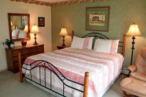 a bedroom with a bed with two lamps and a chair at Fawn Valley Inn- 240 condo in Estes Park