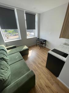 ein Wohnzimmer mit einem Sofa und 2 Fenstern in der Unterkunft Airport Apartment View Self Check-In Free parking in Vilnius
