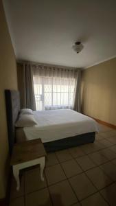 a bedroom with a large bed and a window at Entire 4 bedroom house in Midrand, Johannesburg in Randjesfontein