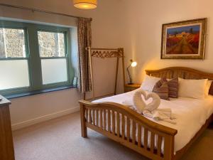 a bedroom with a bed with a swan on it at Stylish~Tasteful~2Bed~2Bath~Central~Townhouse in Penzance