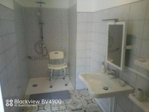 a bathroom with a sink and a chair in it at Aquadetente loudeac in Loudéac